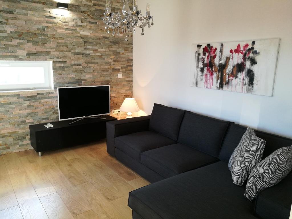 - un salon avec un canapé et une télévision dans l'établissement Apartments Aida Rovinj, à Rovinj