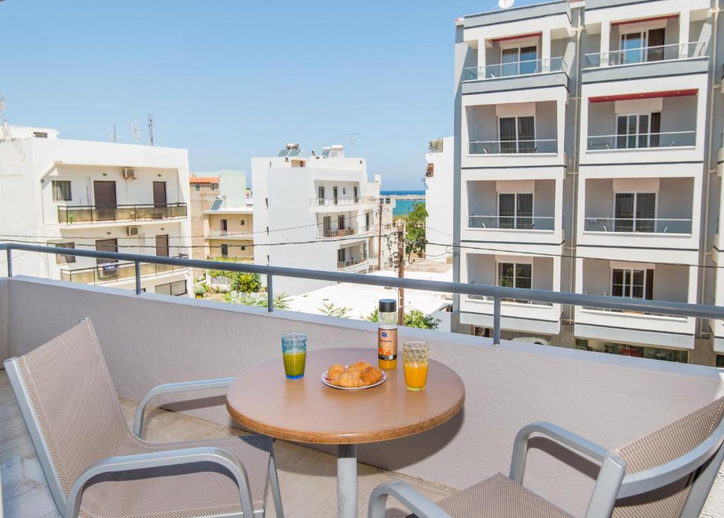 stół i krzesła na balkonie z widokiem w obiekcie Christina's Luxury Apartment w Retimnie