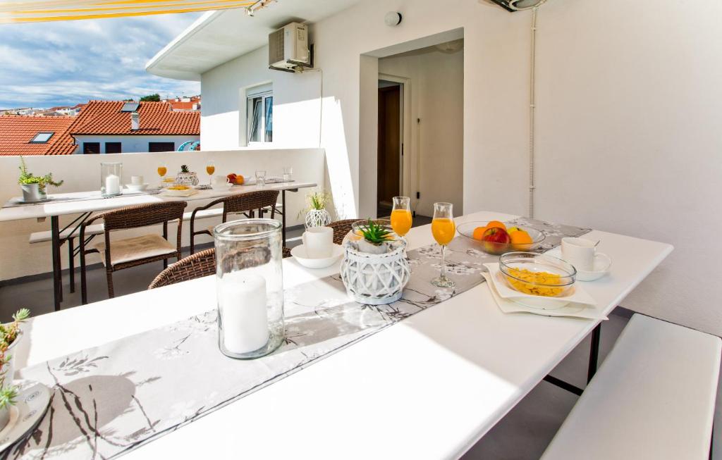 una mesa blanca con comida y bebidas en el balcón en Apartments Ana I, en Hvar