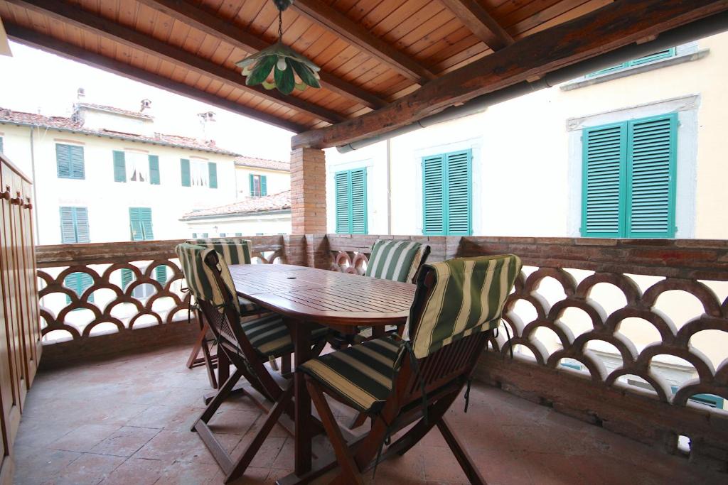 un tavolo in legno e sedie sul balcone. di Via Vittorio Emanuele 60 a Lucca