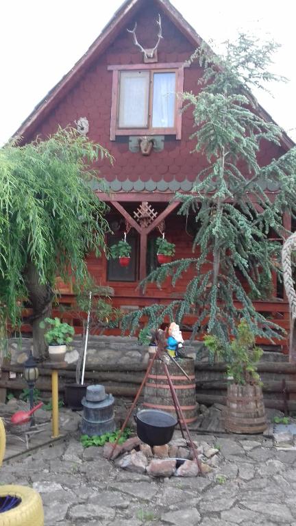 une maison rouge avec un seau devant elle dans l'établissement Casa Vladut, à Babadau