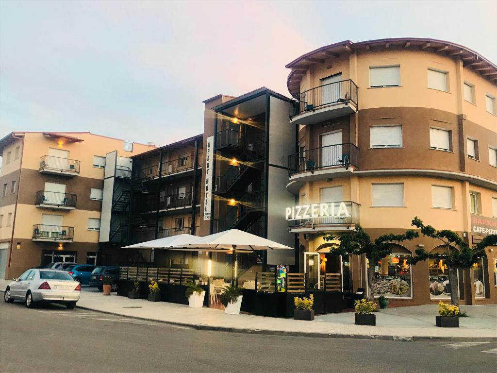 un bâtiment dans une rue avec une voiture garée devant dans l'établissement Apartamentos Giuliano, à Empuriabrava