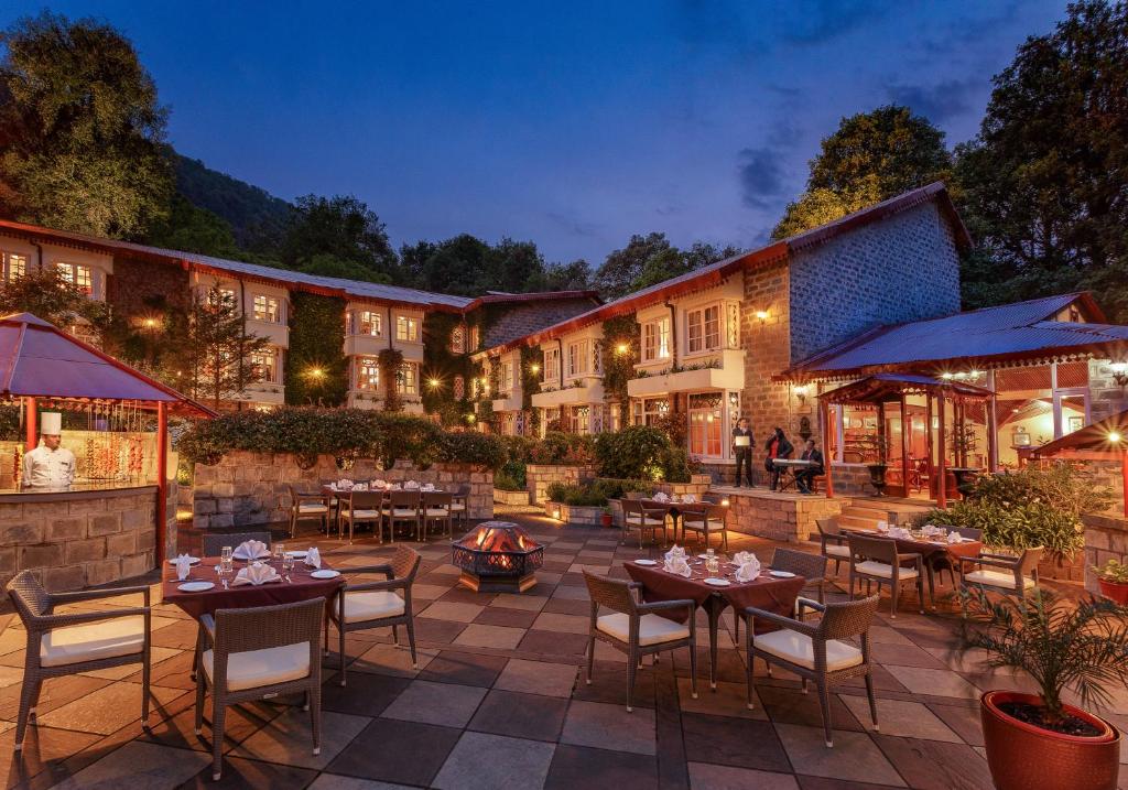 an outdoor patio with tables and chairs and a fire pit at The Naini Retreat, Nainital by Leisure Hotels in Nainital