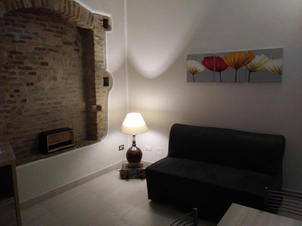 - un salon avec un canapé et une lampe dans l'établissement Via Roma 12, à Messina