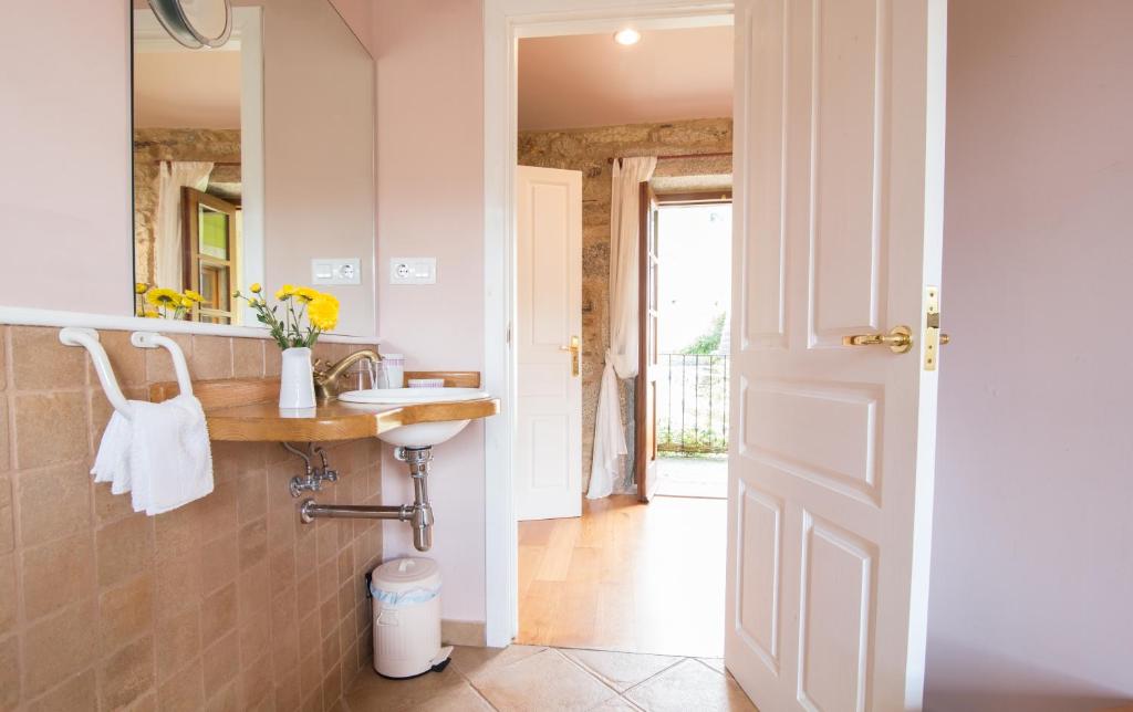 La salle de bains est pourvue d'un lavabo et d'un miroir. dans l'établissement Casa Rural Graña da Acea, à Monfero