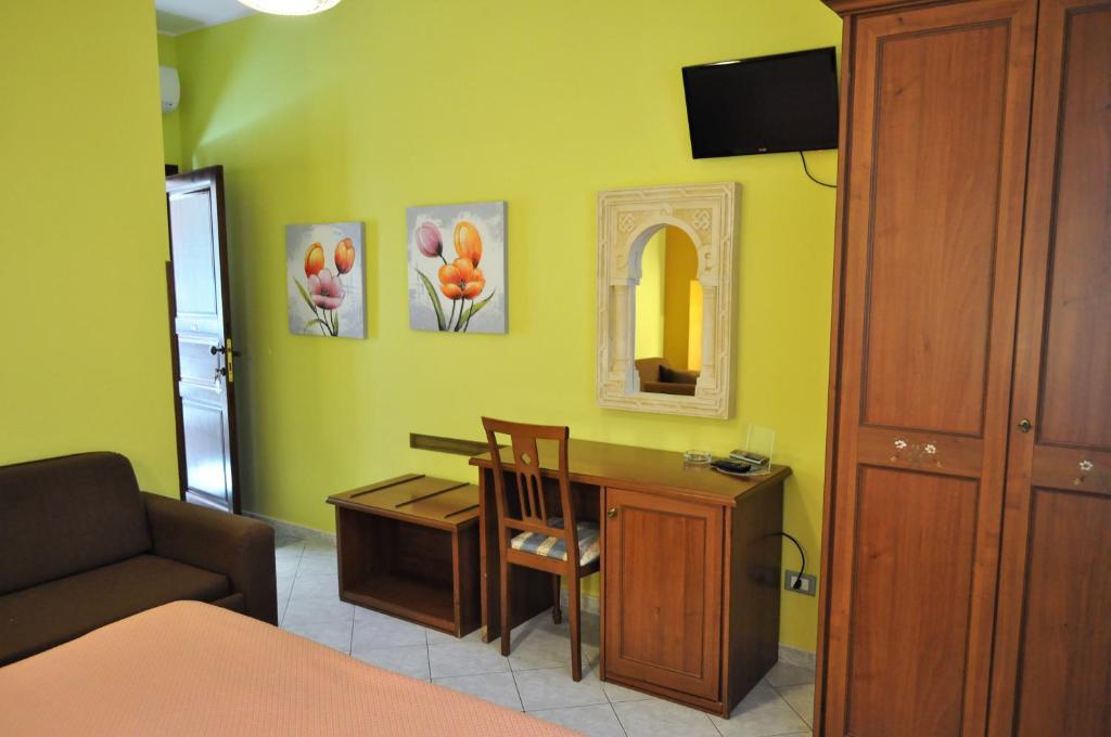 a room with a desk and a chair and a mirror at Al-Tair in San Vito lo Capo