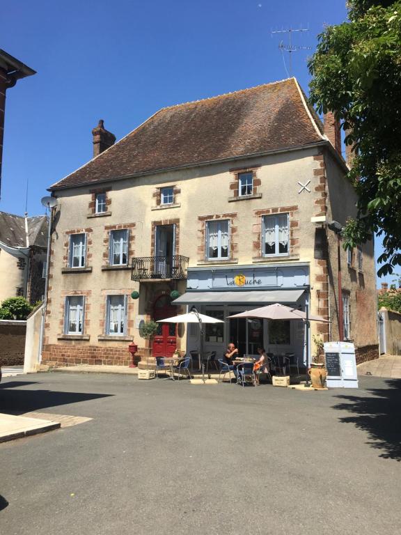 a large building with tables and chairs in front of it at La Ruche Bed & Breakfast, Chaillac in Chaillac