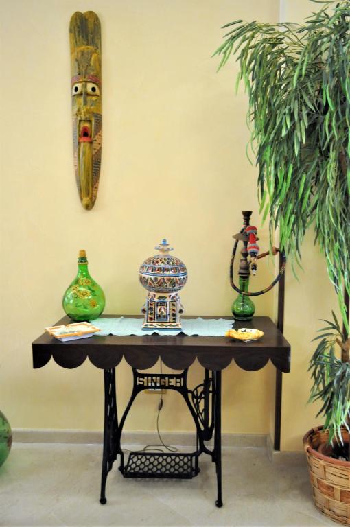 a table with two vases on top of it at Al-Tair in San Vito lo Capo