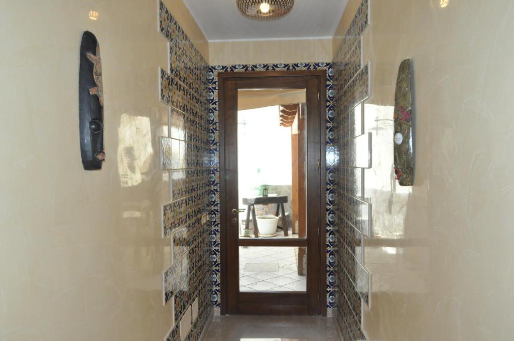 a hallway with a door and tiles on the wall at Al-Tair in San Vito lo Capo