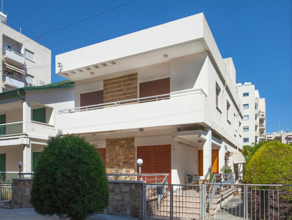 una casa blanca con una valla delante en Despoina Town House, en Limassol
