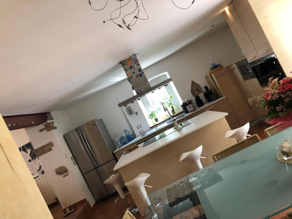 a kitchen with a counter and some white chairs at Villino CORTEBOZZINI in Bardolino