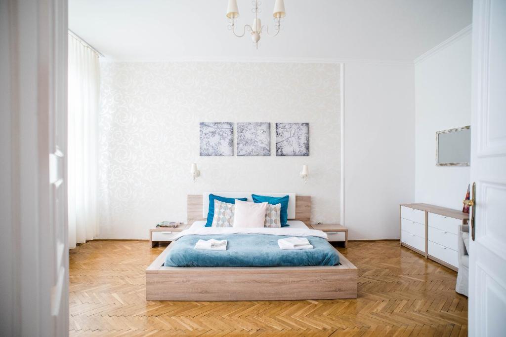 a bedroom with a large bed with blue pillows at Nine Trees Apartment in Budapest