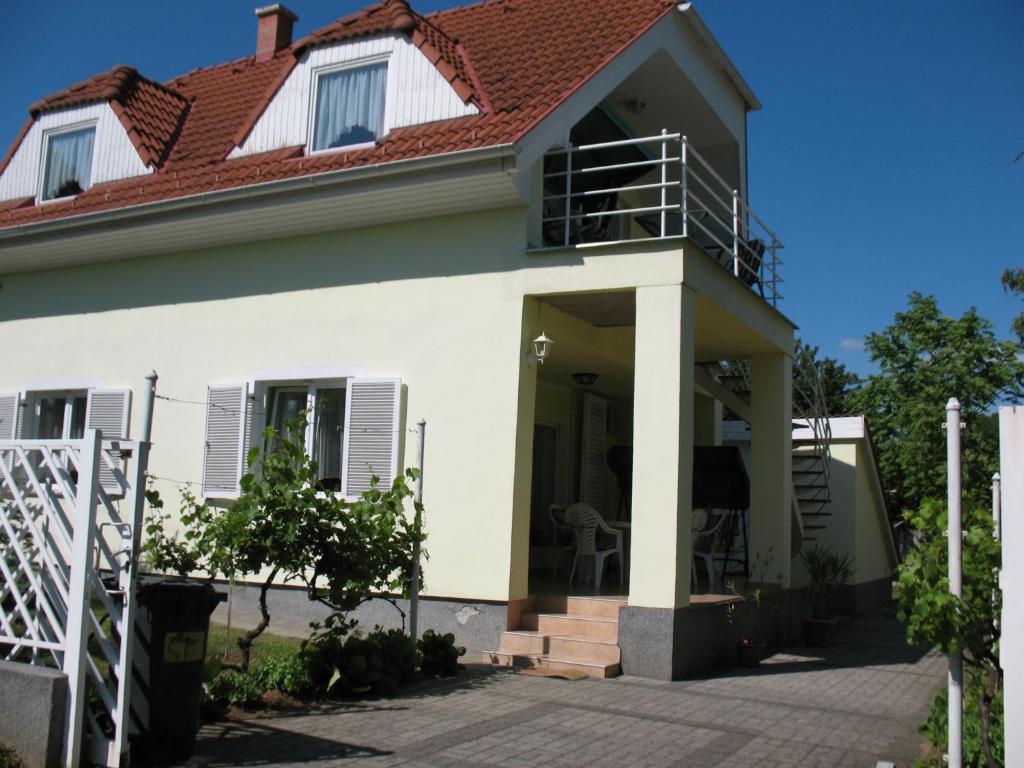 a house with a porch and a balcony at Apartman Alexa in Ábrahámhegy