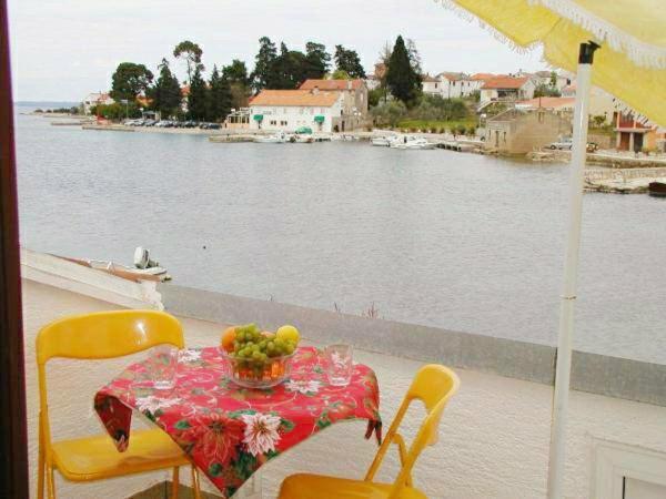 a table with a bowl of fruit on a balcony at Apartments Lukoran in Lukoran