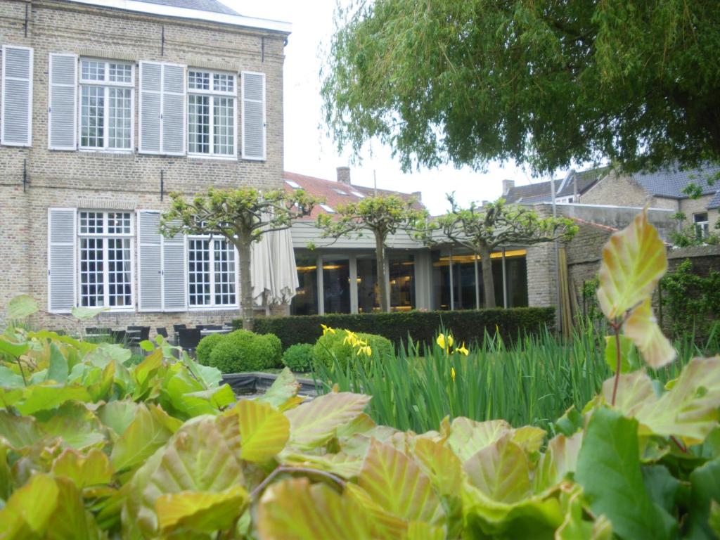 um jardim em frente a uma casa com plantas em Amaryllis Hotel Veurne em Veurne