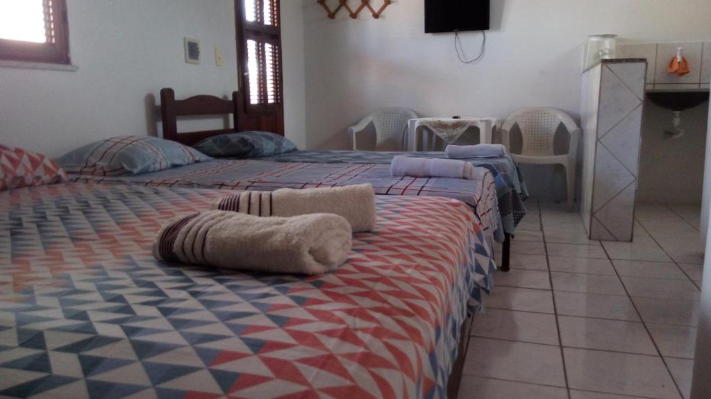 En eller flere senge i et værelse på Suítes Centro Praia