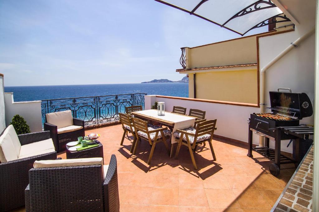 d'un balcon avec une table et des chaises donnant sur l'océan. dans l'établissement Loft Vista Sul Mare, à Letojanni