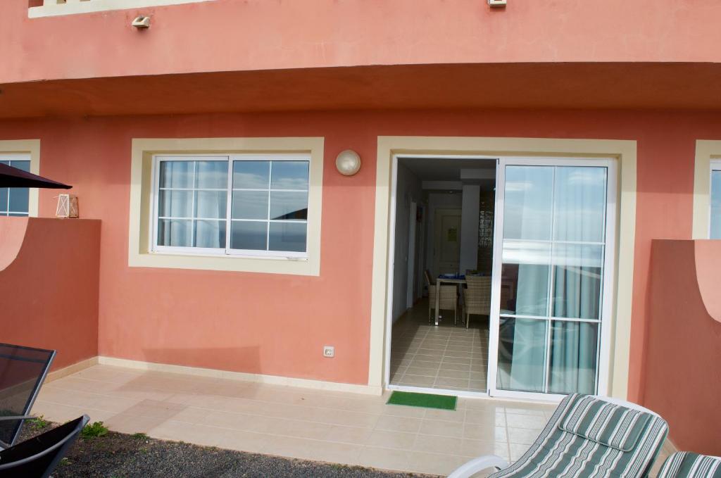 a house with a door and two chairs outside at Residencial Playa Paraiso in Costa Calma