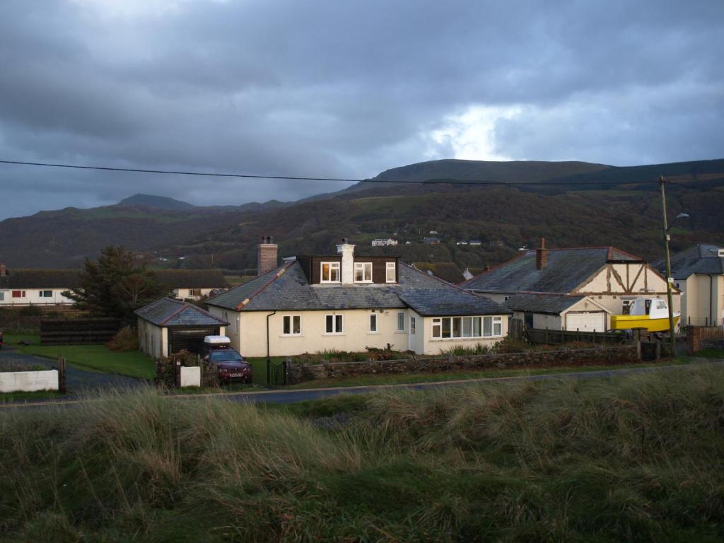 un grupo de casas con montañas en el fondo en Moorings, en Fairbourne