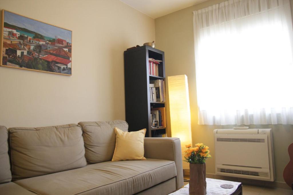 sala de estar con sofá y estante para libros en Sunny apartment in the heart of Athens Preview listing, en Atenas