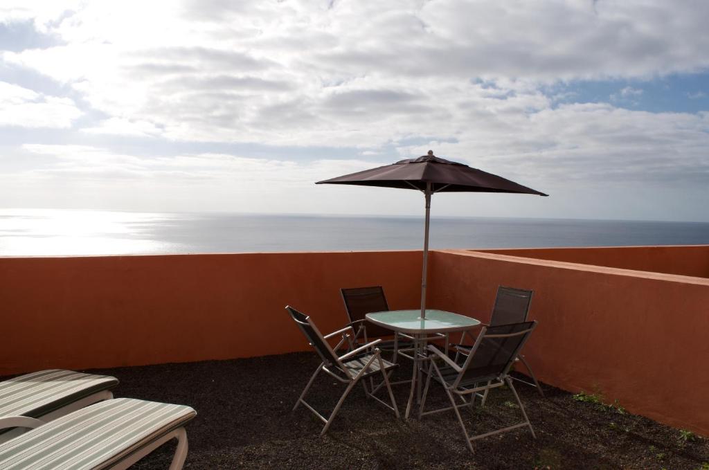 a table and chairs with an umbrella on a balcony at Residencial Playa Paraiso in Costa Calma
