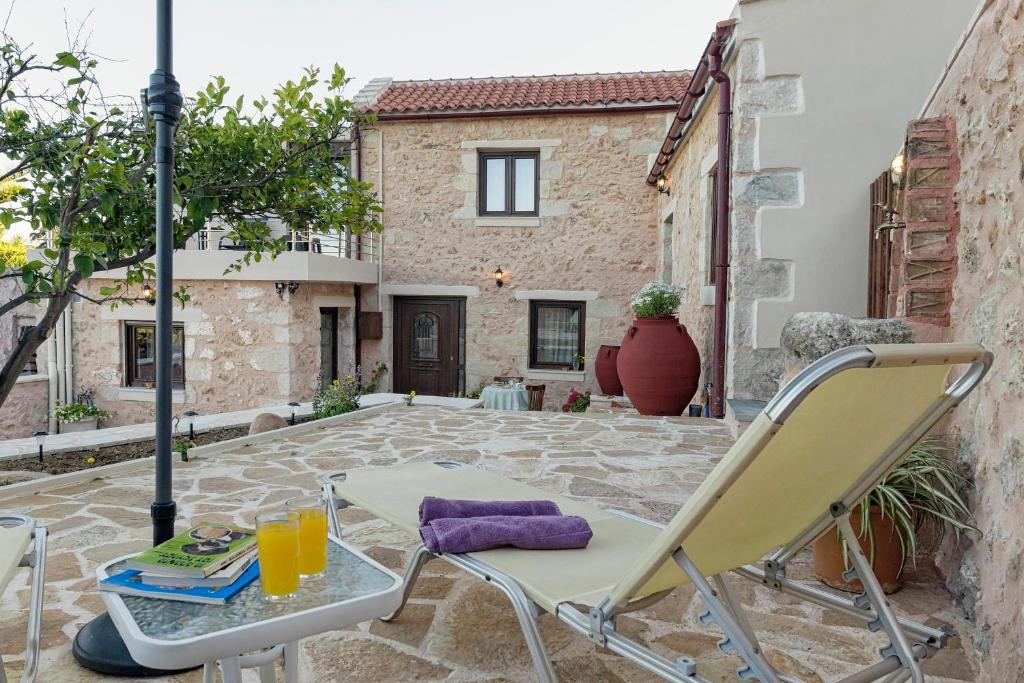 patio con sedie e tavolo con succo d'arancia di Smaragda Stone Villa a Vamos