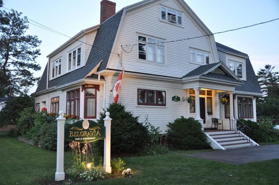 a white house with a sign in front of it at Belgravia B&B in Truro