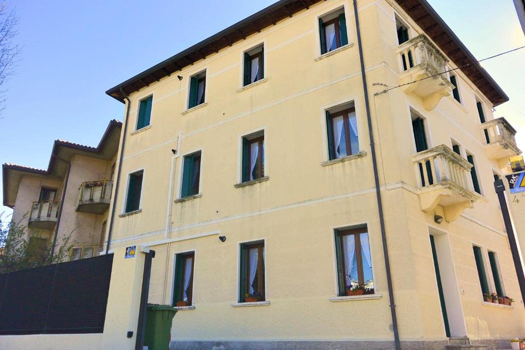 un grande edificio giallo con finestre su strada di Ca' Nova Apartments a Bassano del Grappa