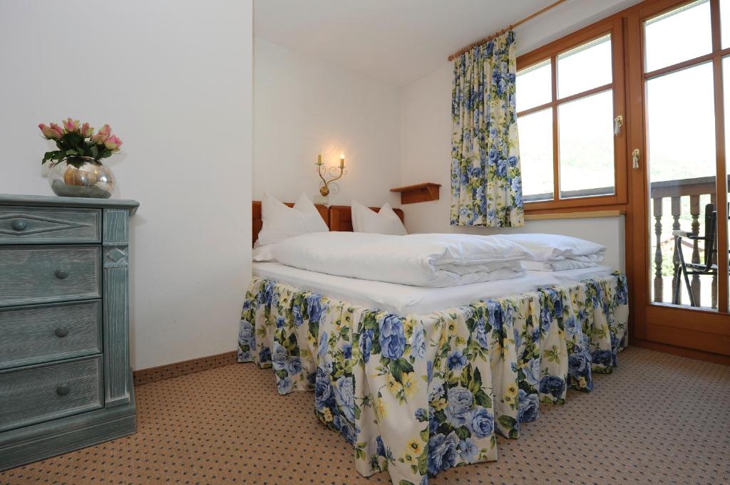 ein Schlafzimmer mit einem Bett mit einer Kommode und einem Fenster in der Unterkunft Villa 17 in Gaschurn