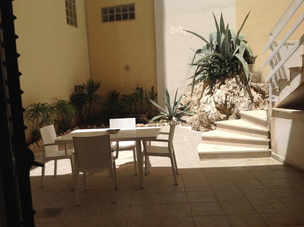 un tavolo e sedie in un cortile con piante di Casa BELLAVISTA tra MARE e TERME a Santa Cesarea Terme
