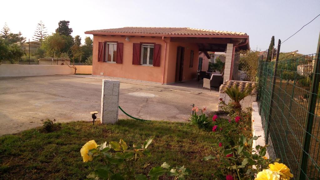 a small house with a fence and a yard at Villa Origano in Santa Maria del Focallo