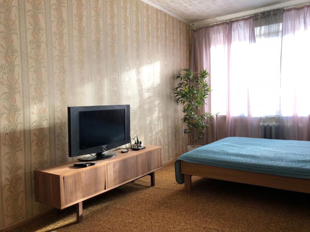 エカテリンブルクにあるPedagogicheskaya 4のベッドルーム1室(テレビ付)、キャビネット(ベッド付)