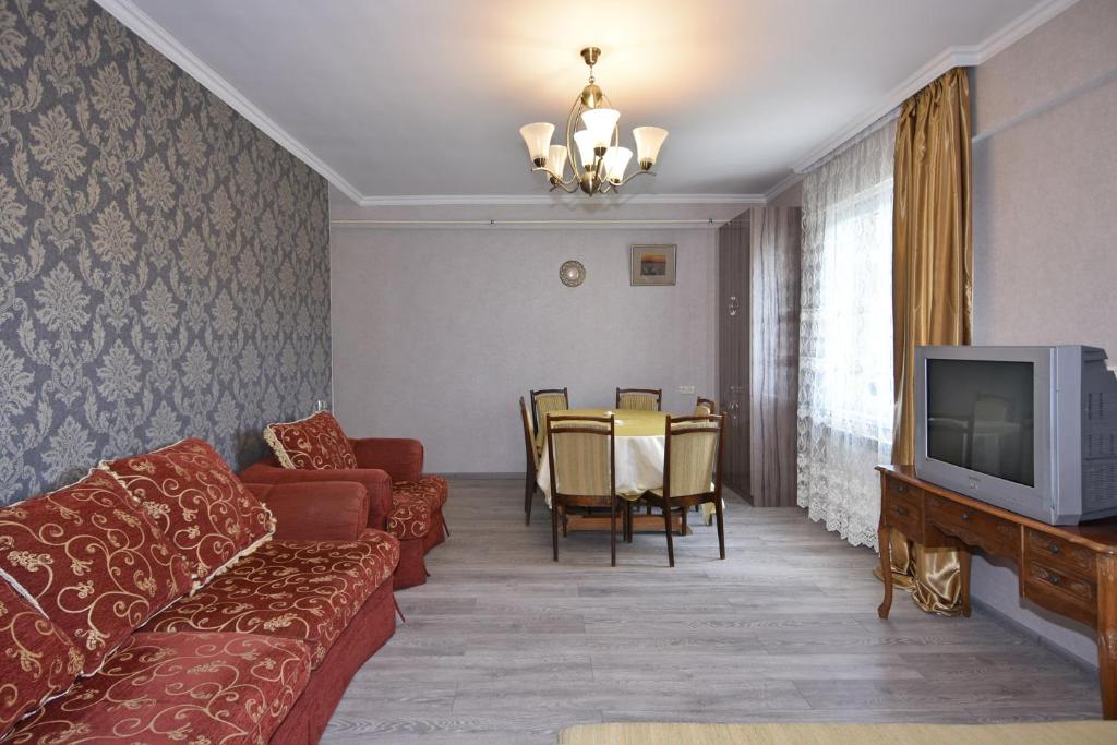 a living room with a couch and a tv at Уютная квартира около медицинского центра Астхик! in Yerevan