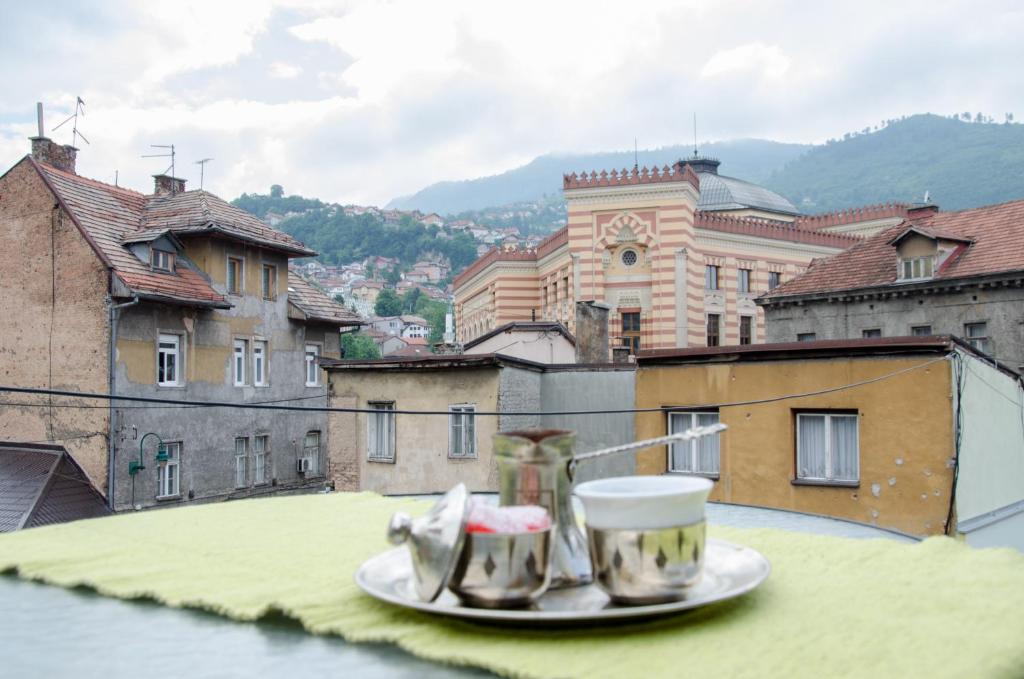 two cups on a plate on top of a building at Guesthouse Unique in Sarajevo