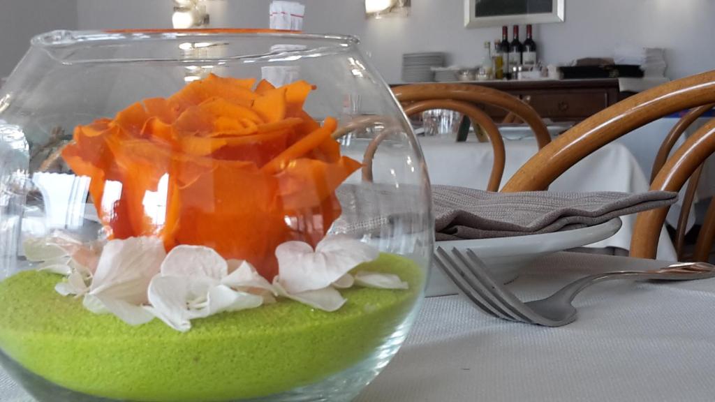 a glass vase filled with vegetables on a table at Hotel Belvedere in Venice-Lido
