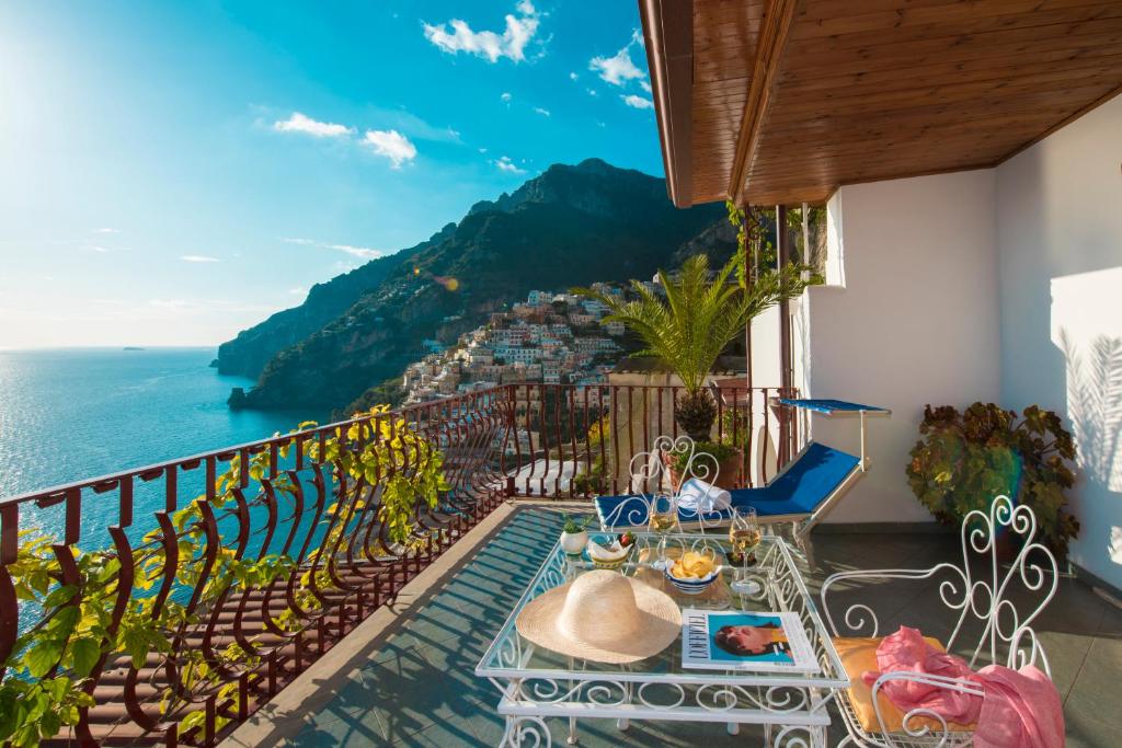 uma varanda com uma mesa e vista para o oceano em Hotel Eden Roc em Positano