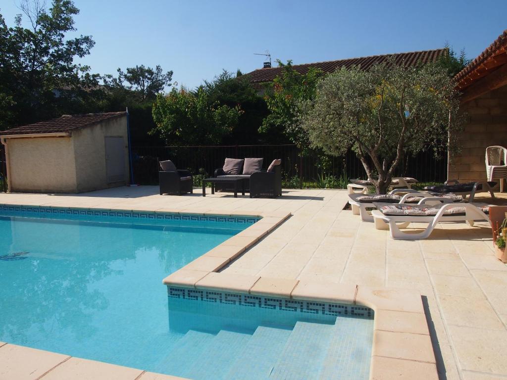 une piscine avec des chaises longues et une terrasse dans l'établissement Les Buis, à Carpentras