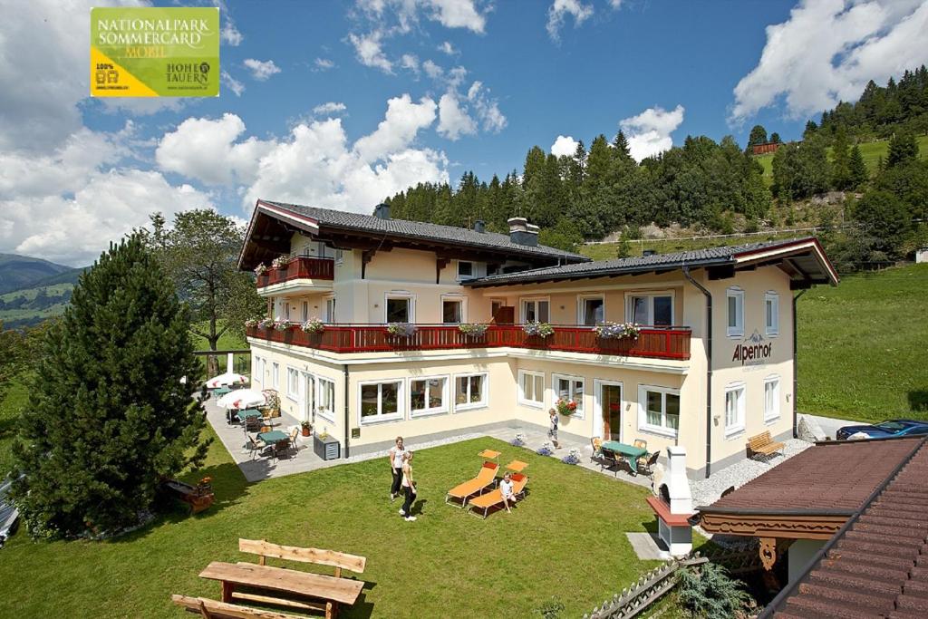 a large house with people standing in the yard at Alpenhof Apartments in Mittersill