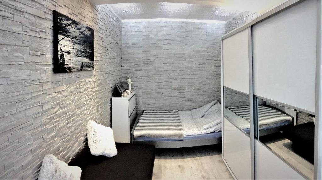 ウェバにあるŁeba Apartamentのレンガの壁にベッドが備わる小さな客室です。
