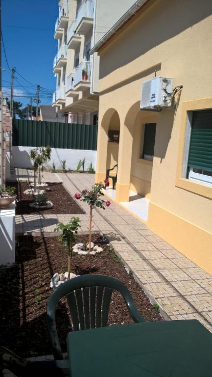 a chair sitting in a yard next to a building at Casa do Limoeiro in Quinta do Conde