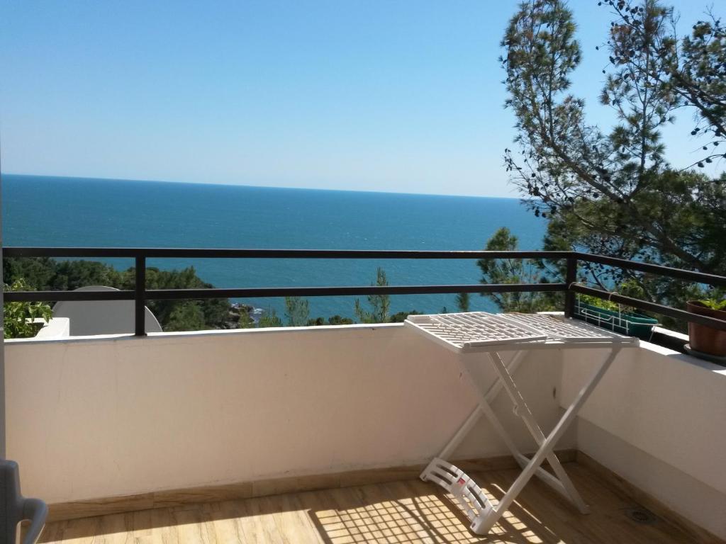 a table on a balcony with the ocean in the background at Apartment Ralf in Ulcinj