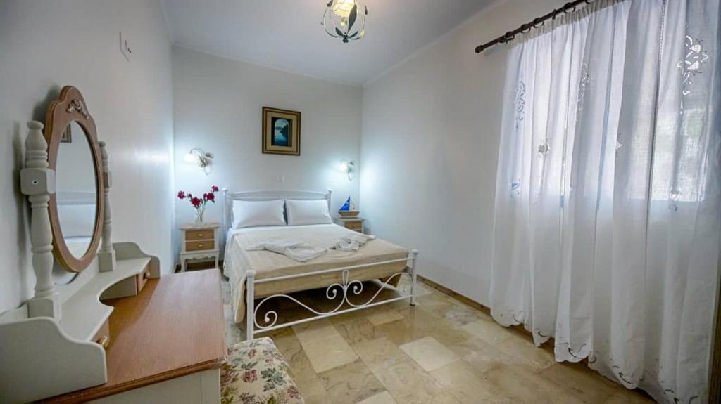 a bedroom with a bed and a large window at Feakia apartment 2 in Agios Gordios