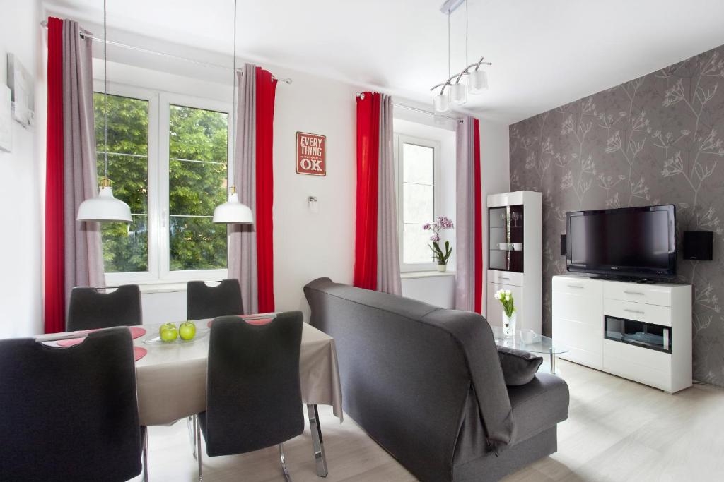 a dining room with red curtains and a table and chairs at City center - Gdańsk Old Town Apartment in Gdańsk