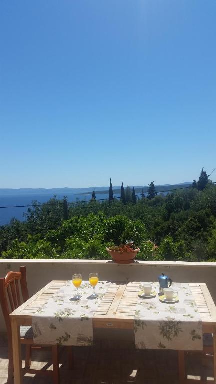 una mesa de madera con dos vasos de zumo de naranja. en Holiday Home Rubinić, en Zavala