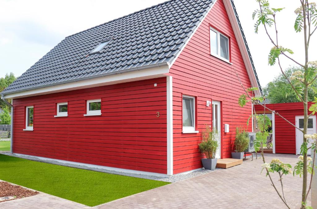 una casa roja con techo negro en Ferienhaus am Alfsee en Rieste