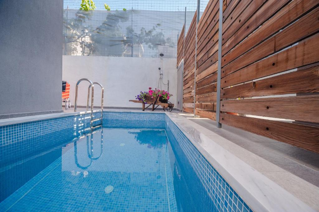 a swimming pool in a house with a wooden fence at Skandalakis Homes & Apartments in Stalos