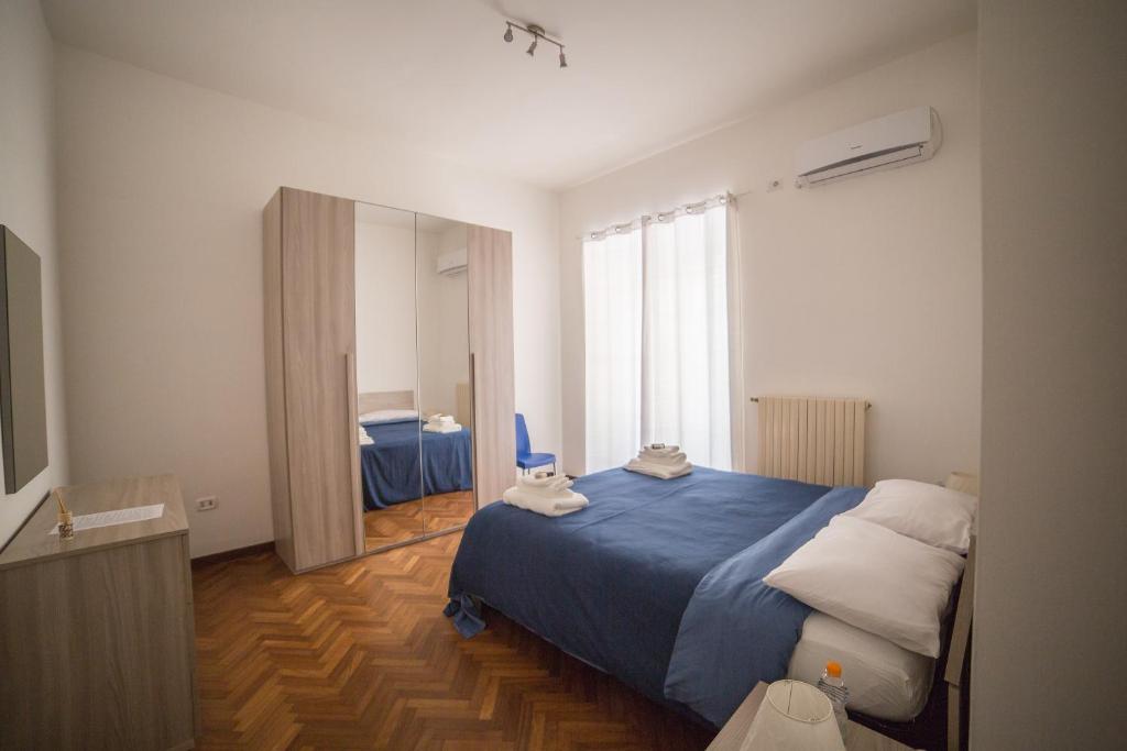 サレルノにあるB&B Feel Salernoのベッドルーム(青いベッド1台、大きな窓付)