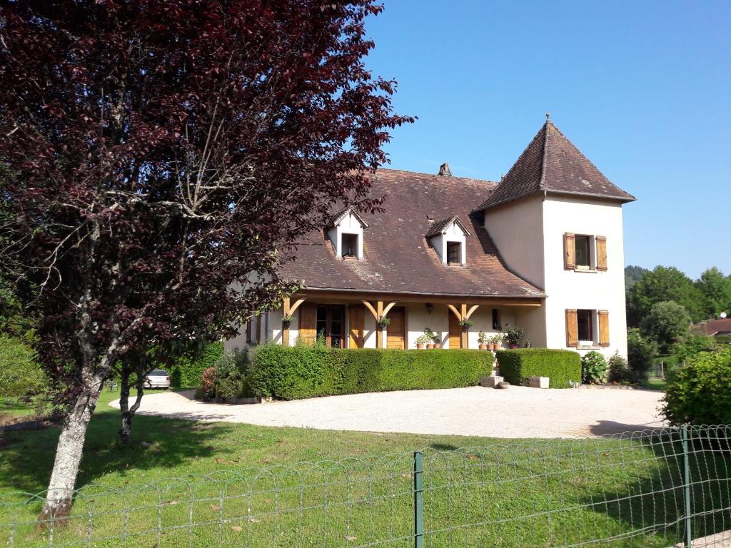 een groot wit huis met een hek ervoor bij Moulin de Latouille in Latouille-Lentillac