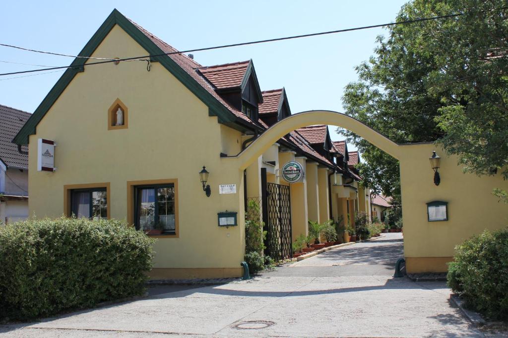 Kópháza的住宿－勒旺達畔茲奧住宿加早餐旅館，街道上一座黄色的建筑,有拱门