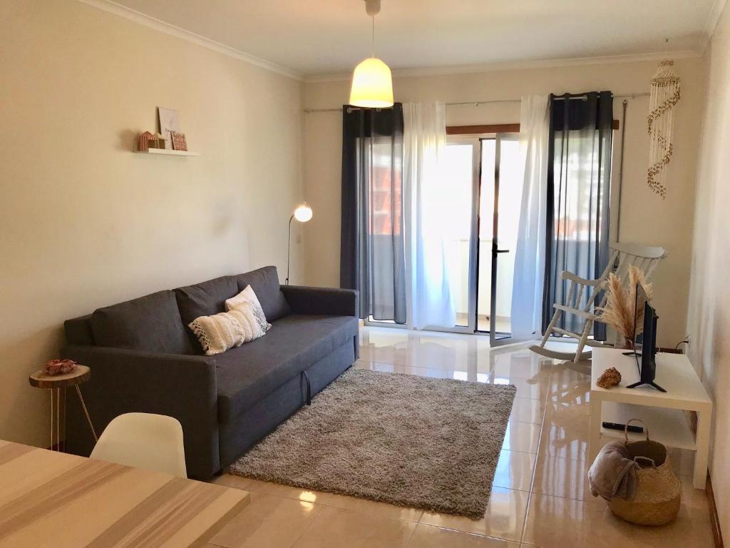 uma sala de estar com um sofá e uma mesa em Nazaré Beach Apartments na Nazaré